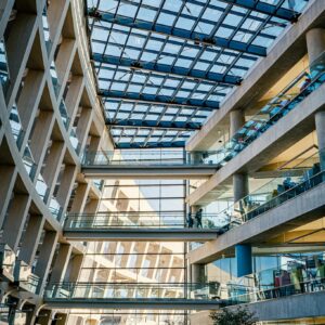 Contemporary shopping mall interior featuring a glass ceiling and multiple floors, emphasizing modern architecture.