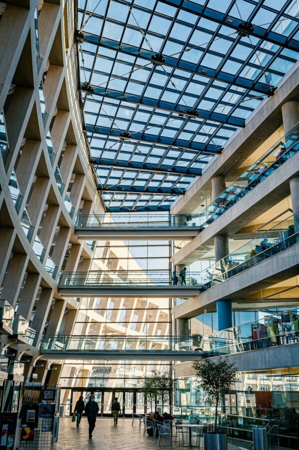 Contemporary shopping mall interior featuring a glass ceiling and multiple floors, emphasizing modern architecture.